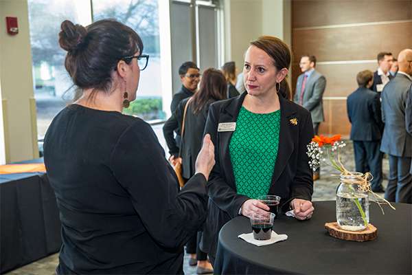 UT Dallas mentor talking with a student at an MBA Mixer